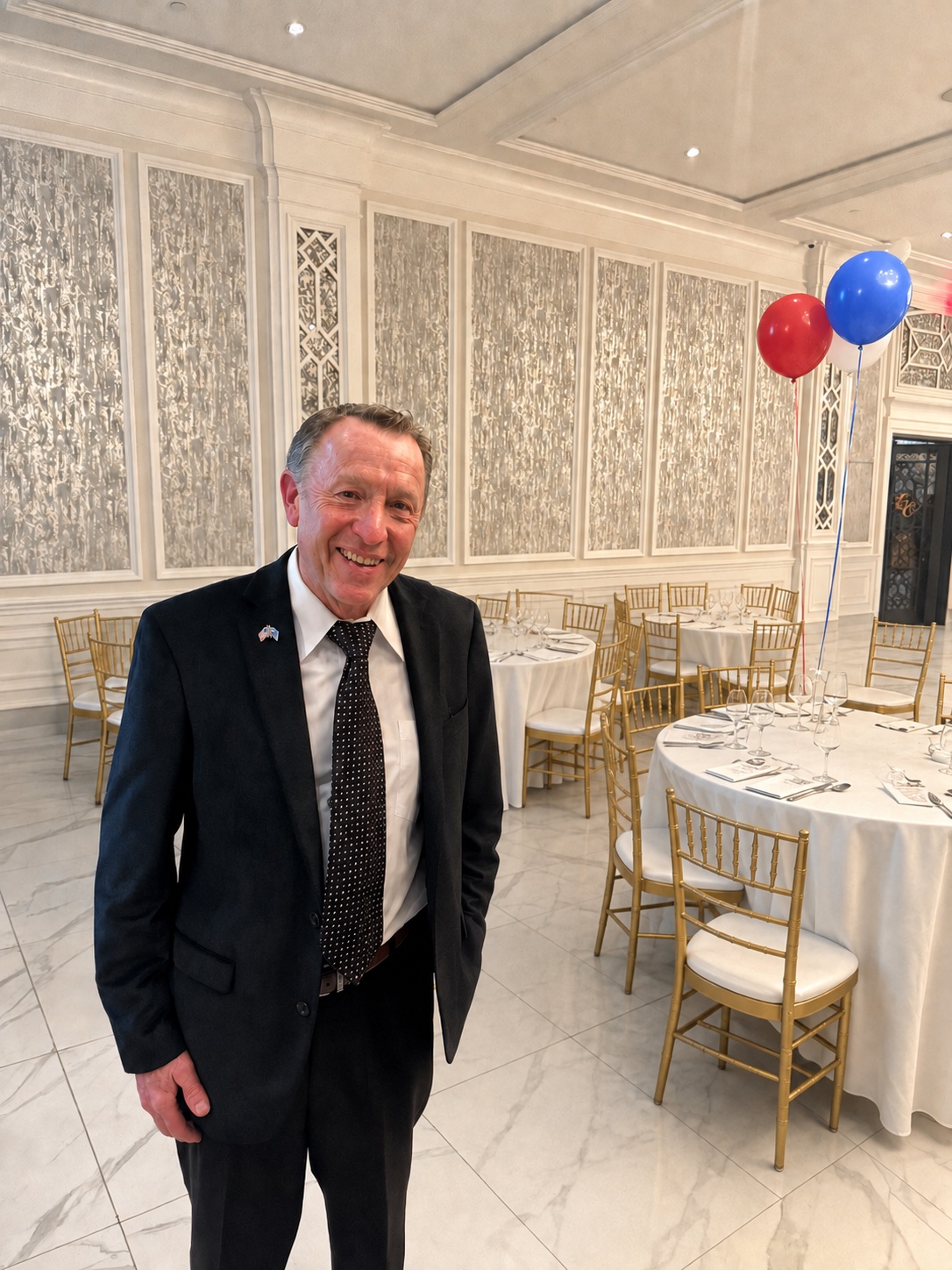Ronald Seifert at a community event with red, white, and blue balloons